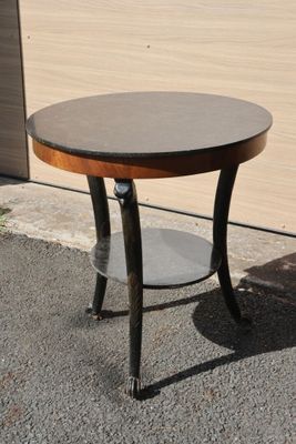 a small round table with a wooden top on the sidewalk