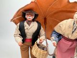 two figurines of a man and a woman with an umbrella