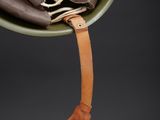 an image of a helmet with a leather strap hanging from it ' s side