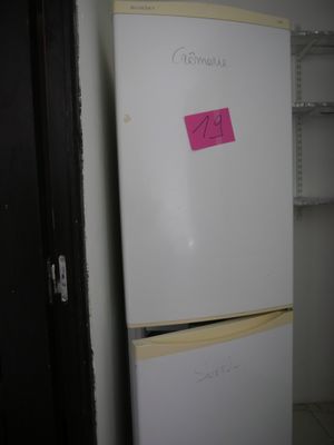 a white refrigerator with a pink sticker on it