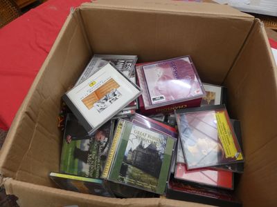 une boîte en carton remplie de DVD et de CD posée sur une table