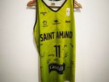 un maillot de basket vert suspendu à un cintre dans une pièce