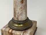 an image of a marble column with a metal base