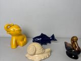 trois figurines d'animaux et un escargot posés sur une table