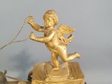 a gold statue of an angel on a cart with a dog