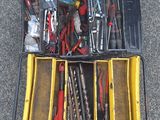 de nombreux outils dans une boîte à outils posée par terre
