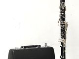 a black and silver clarinet next to a black case