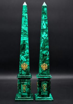 a pair of green marble obelisks with gold accents
