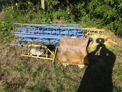 a blue metal structure sitting in the middle of a field
