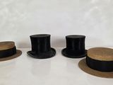 trois chapeaux sont alignés sur une table devant un fond blanc