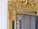 a mirror with a gold frame on the wall