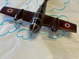 un petit avion en jouet posé sur une feuille de papier