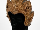 une tête de mannequin noire coiffée d'un chapeau doré