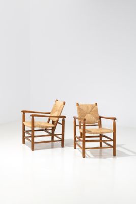 two wooden chairs sitting next to each other on a white floor