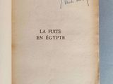 un livre ouvert avec une écriture dessus, posé sur une table