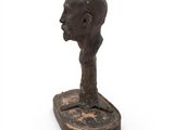 a close up of a statue of a man ' s head on a stand