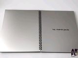 a silver notebook with writing on it sitting on a table