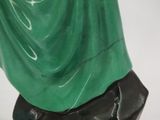 statue of a woman in a green dress on a black base