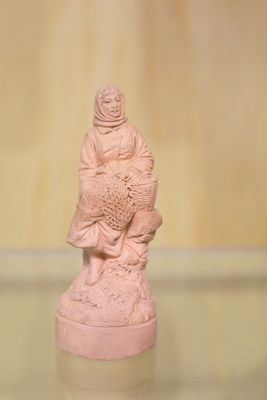 une petite statue représentant une personne tenant un poisson