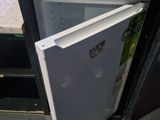 un petit réfrigérateur dont la porte est ouverte et repose sur le sol