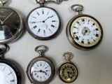several different types of pocket watches are displayed on a white surface