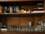 une étagère en bois sur laquelle sont posés de nombreux verres et bouteilles