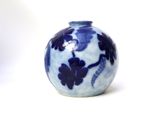 a blue and white vase sitting on a white surface