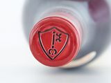 a close up of a bottle of wine with a red cap