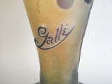 un vase sur lequel est inscrit un nom, posé sur une table