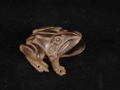 a close up of a frog figurine on a black background