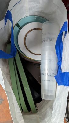 un sac blanc orné d'un ruban bleu et d'une bouteille de vin
