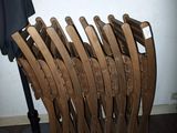 une pile de chaises en bois posée à côté d'une lampe