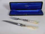 two forks and a knife in a case on a table