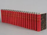 books lined up in a row on a gray surface
