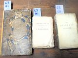 Trois vieux livres sont posés les uns à côté des autres sur une table.