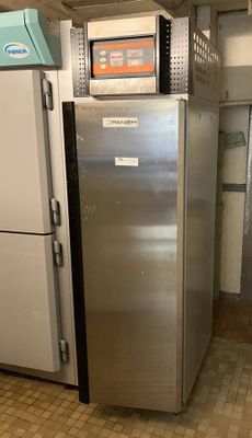 a silver refrigerator in a room with a tiled floor