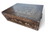an old wooden box with writing on it sitting on a white surface