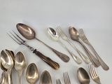 a lot of spoons and forks laid out on the table