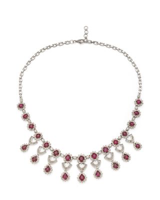 a necklace with pink stones and silver chains on a white background