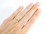 a woman ' s hand with a gold ring on it