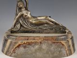 sculpture représentant une femme allongée sur un socle en marbre