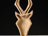a close up of a sculpture of a deer ' s head on a table