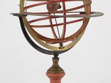 une ancienne maquette de cadran solaire posée sur un socle en bois
