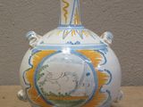 a white vase with a blue and yellow design on it