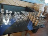 bottles and glasses on a table in a room with a painting