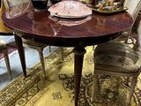 une table avec des chaises et un vase posé dessus