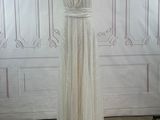 a white dress on a mannequin stand in a room