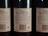 three bottles of wine sitting on top of a wooden table