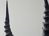 a large antelope with long horns on a wooden chair