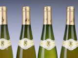 four bottles of wine are lined up in a row